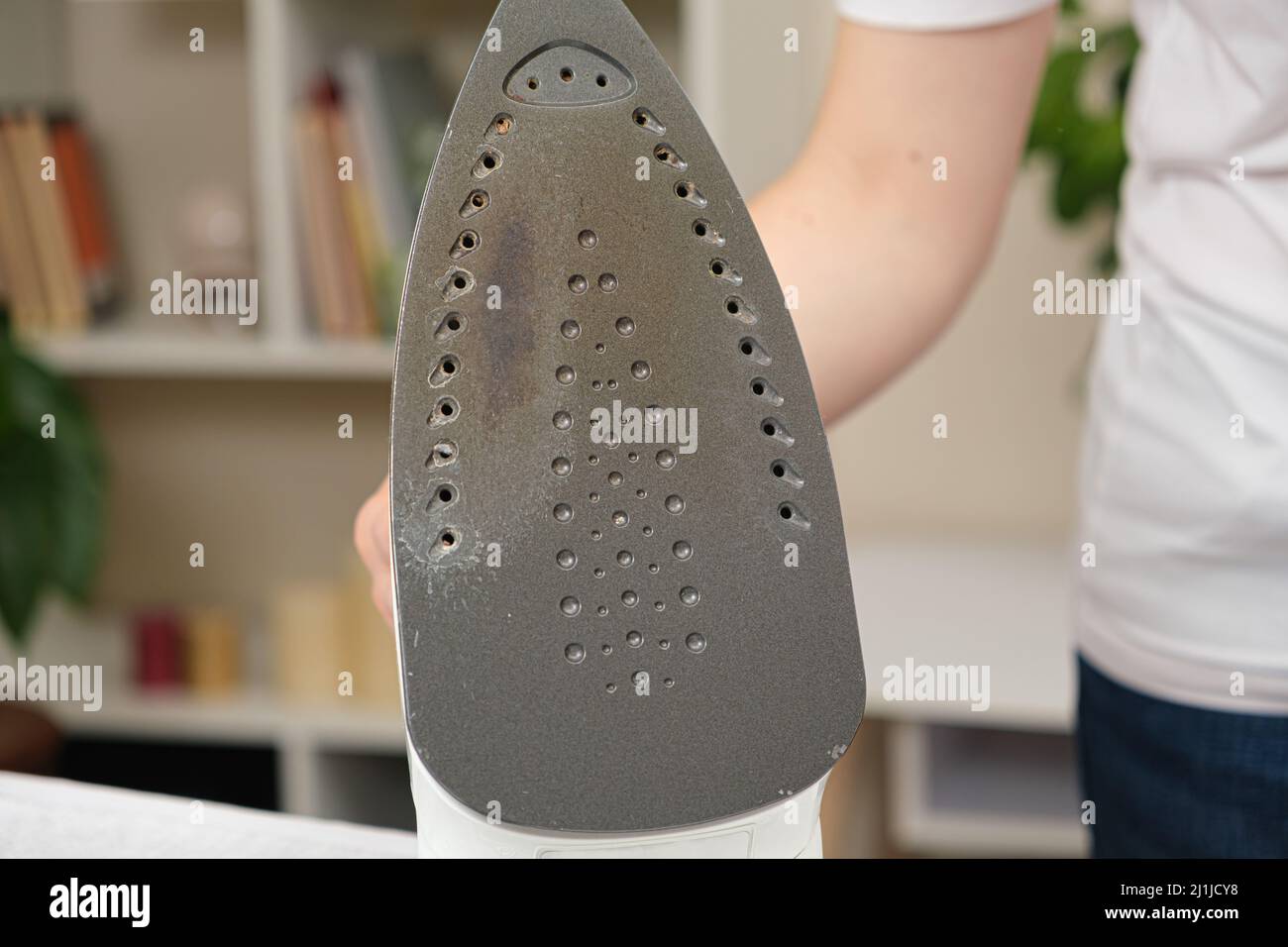Damaged sole of the iron, brown stains and traces of burning with smoke