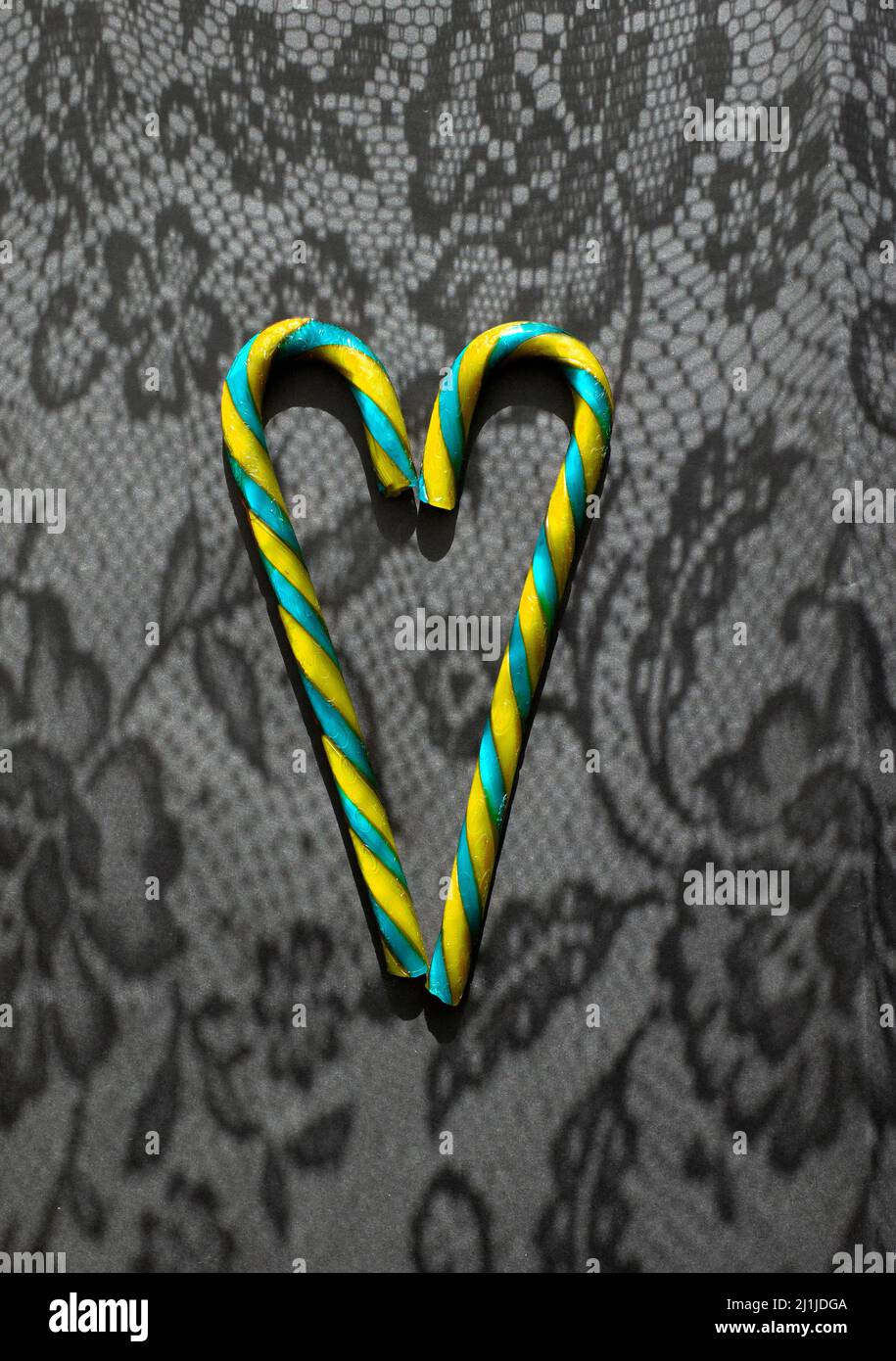 Blue and yellow heart on a black background with laced shadows from lace. Love Ukraine. Place for text. Stand with Ukraine. gratitude to countries of Stock Photo