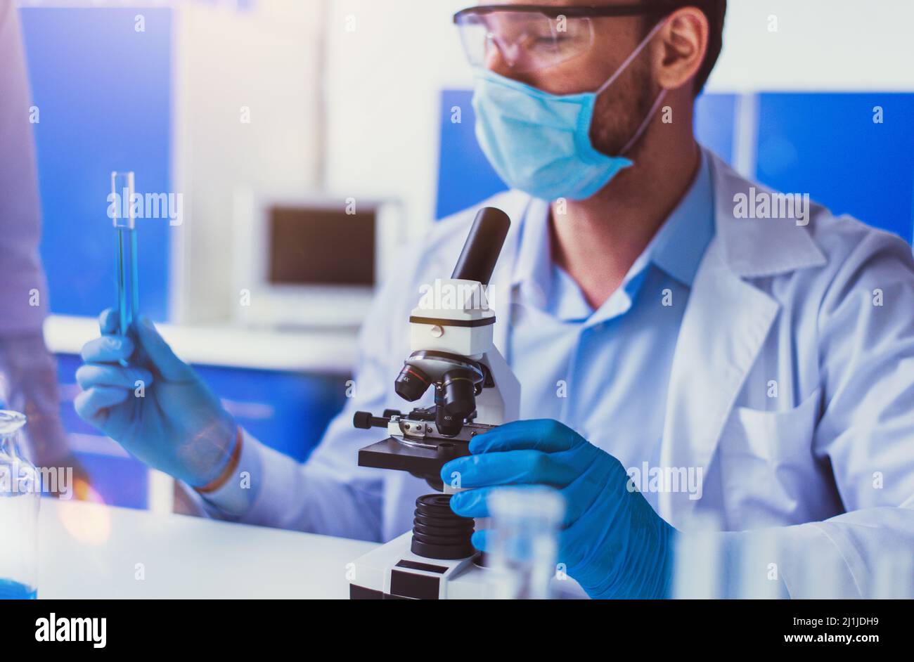 Doctor in the laboratory analyzes samples of codiv-9 under a microscope ...
