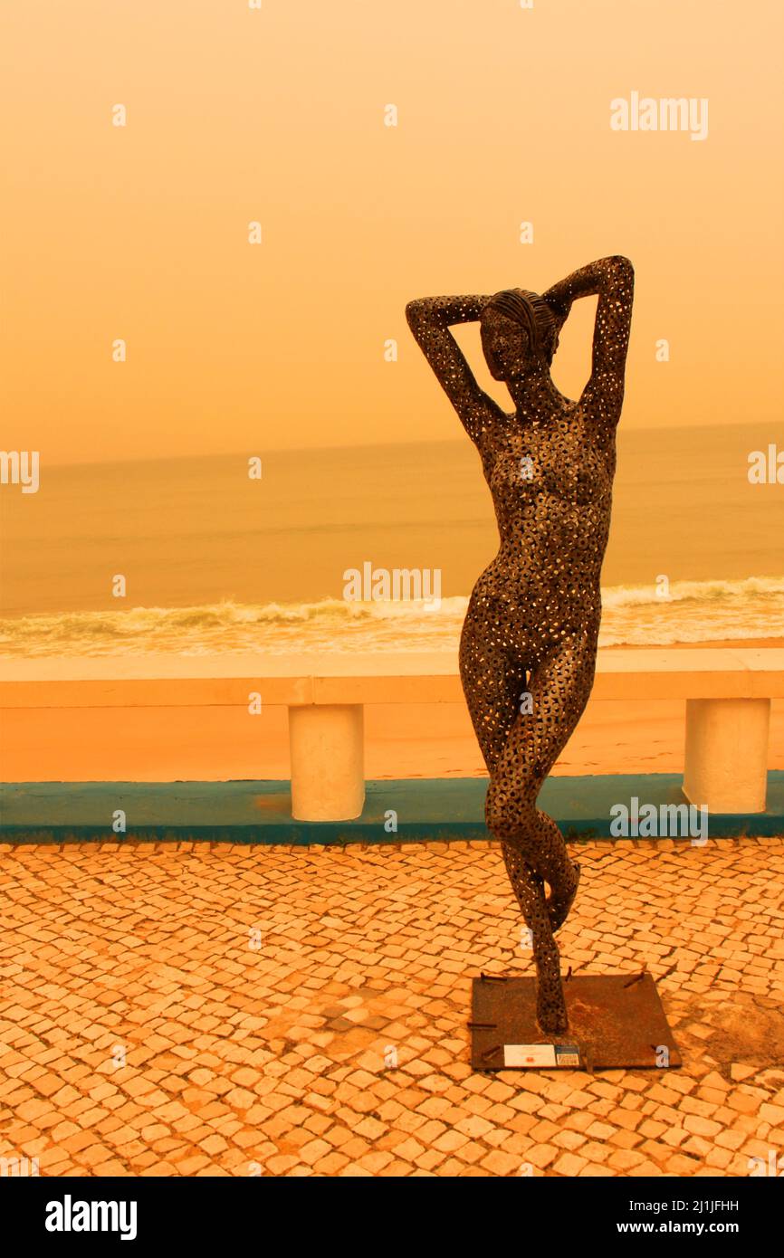 Statue of a woman (recycled material) at the beach in Portugal Stock Photo