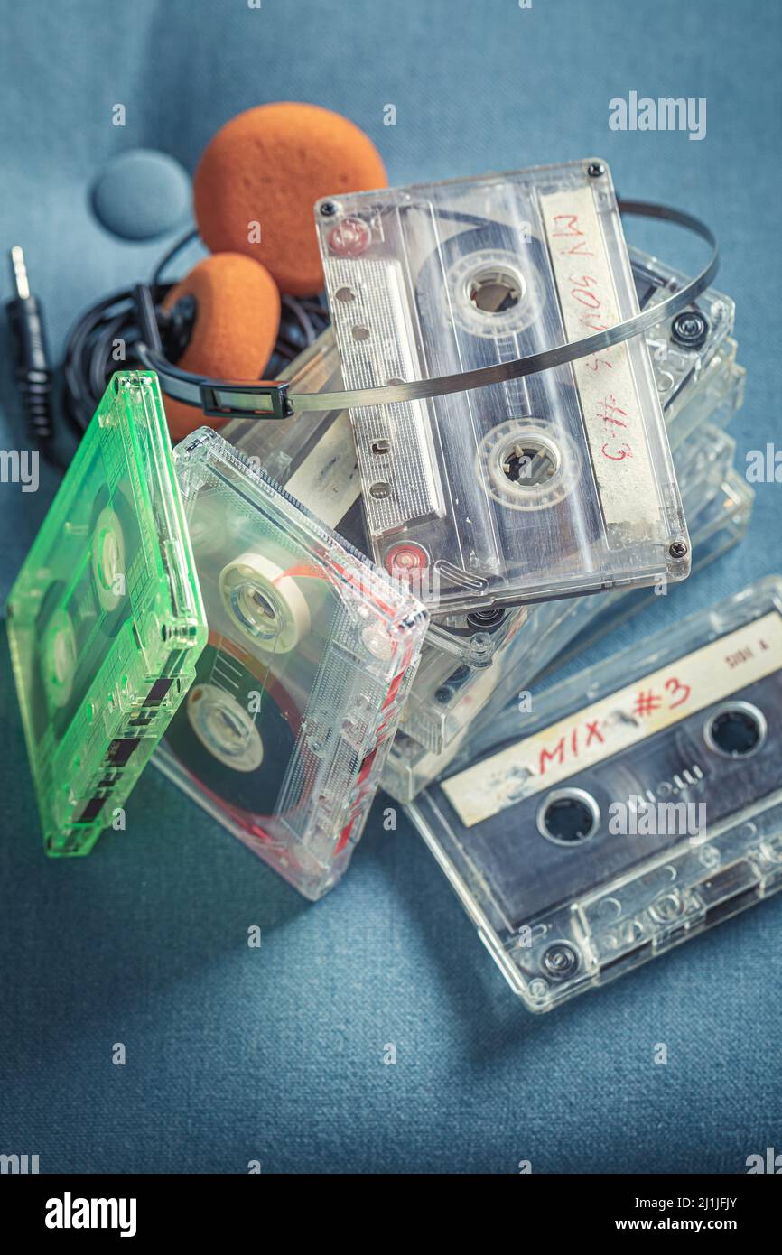Stack of transparent audio cassettes with headphones. Cassette audio