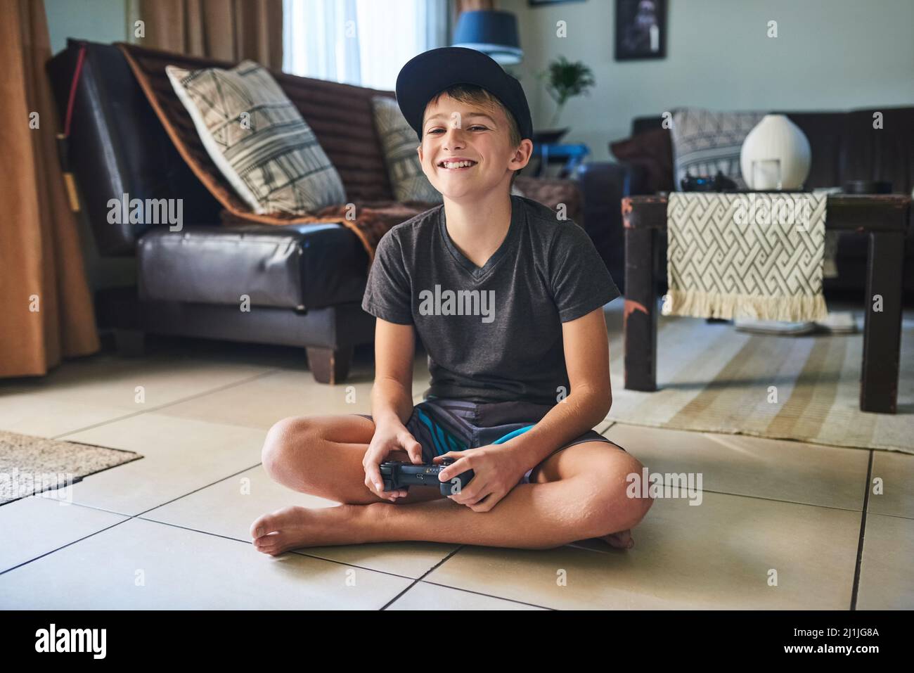 I love this game. Full length portrait of a young boy playing video games at home. Stock Photo