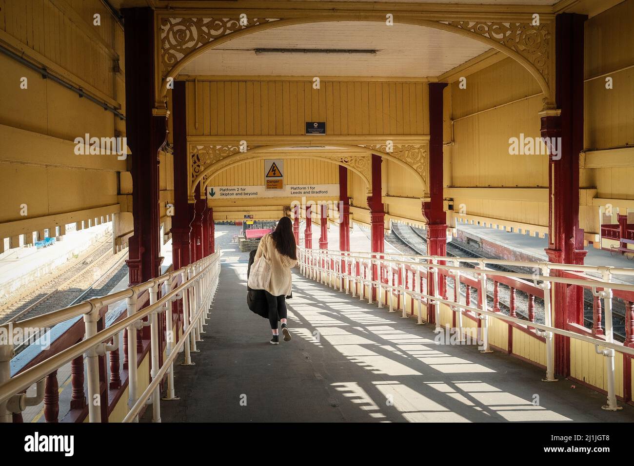 Keighley, West Yorkshire, UK. A young woman walking towards the railway station platform at Keighley Station. Stock Photo