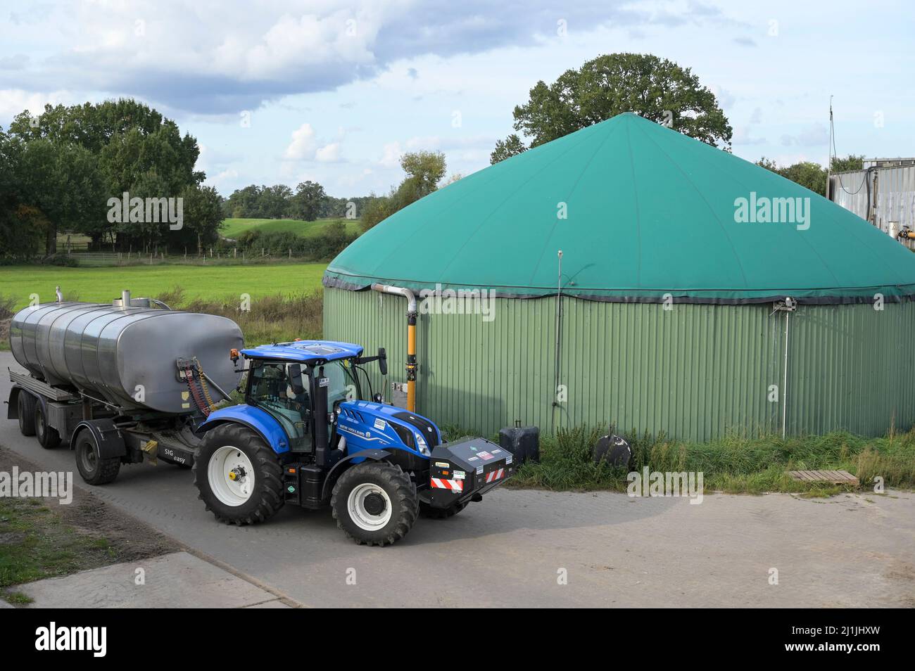 Germany, Biogas Palnt and New Holland Tractor powered by BioMethan gas CNG / DEUTSCHLAND, Damnatz im Wendland, Hof und Biogasanlage, neuer New Holland Traktor T6.180 mit Methanpower mit Gasmotor und Biomethan bzw. CNG Gas Antrieb im Test mit Tankwagen, vorne Zusatztank für CNG Stock Photo