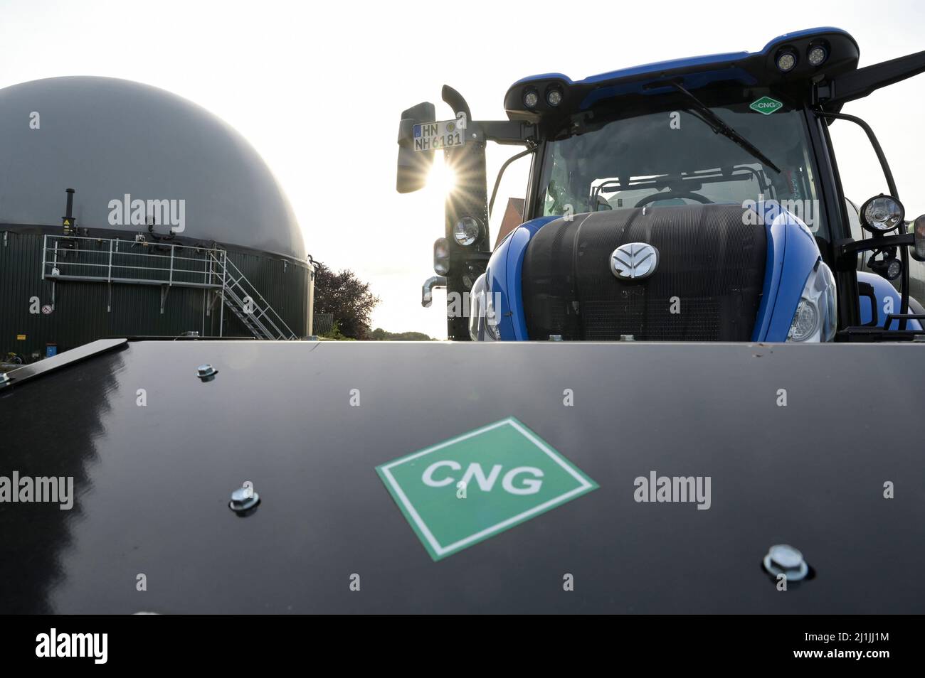 Germany, biogas Tank and New Holland Tractor powered by BioMethan gas CNG / DEUTSCHLAND, Damnatz im Wendland, Hof und Biogasanlage, neuer New Holland Traktor T6.180 mit Methanpower mit Gasmotor und Biomethan bzw. CNG Gas Antrieb im Test, vorne Zusatztank für CNG Stock Photo