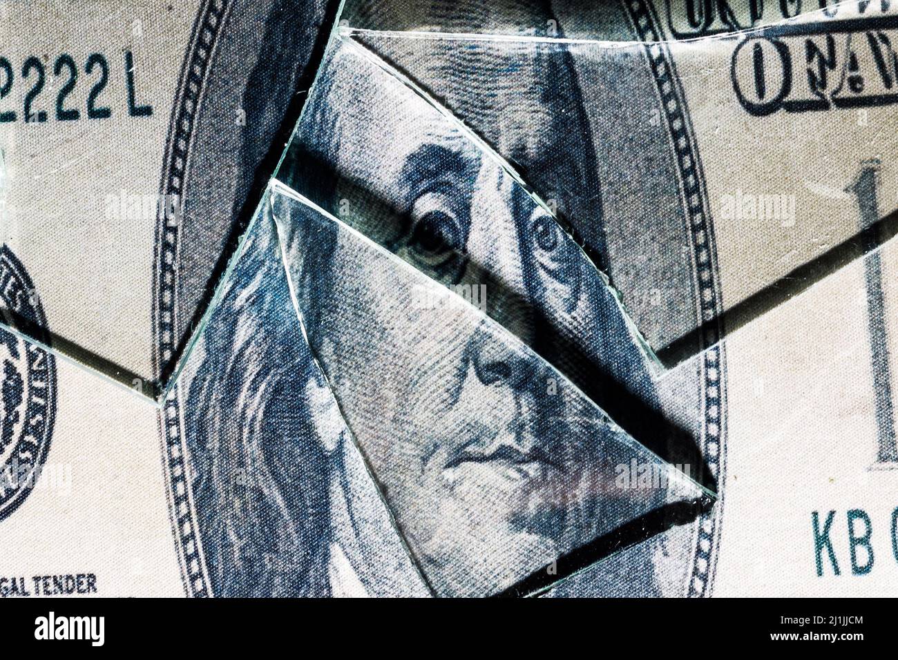 shards of glass on a portrait of Benjamin Franklin on a dollar bill. High quality photo Stock Photo