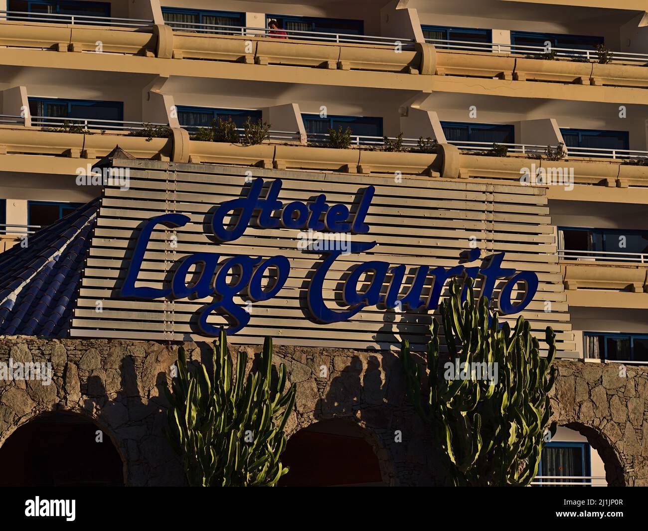 Closeup view of sign above the entrance of Hotel Paradise Lago Taurito, a popular tourist accommodation in southern Gran Canaria in the evening sun. Stock Photo