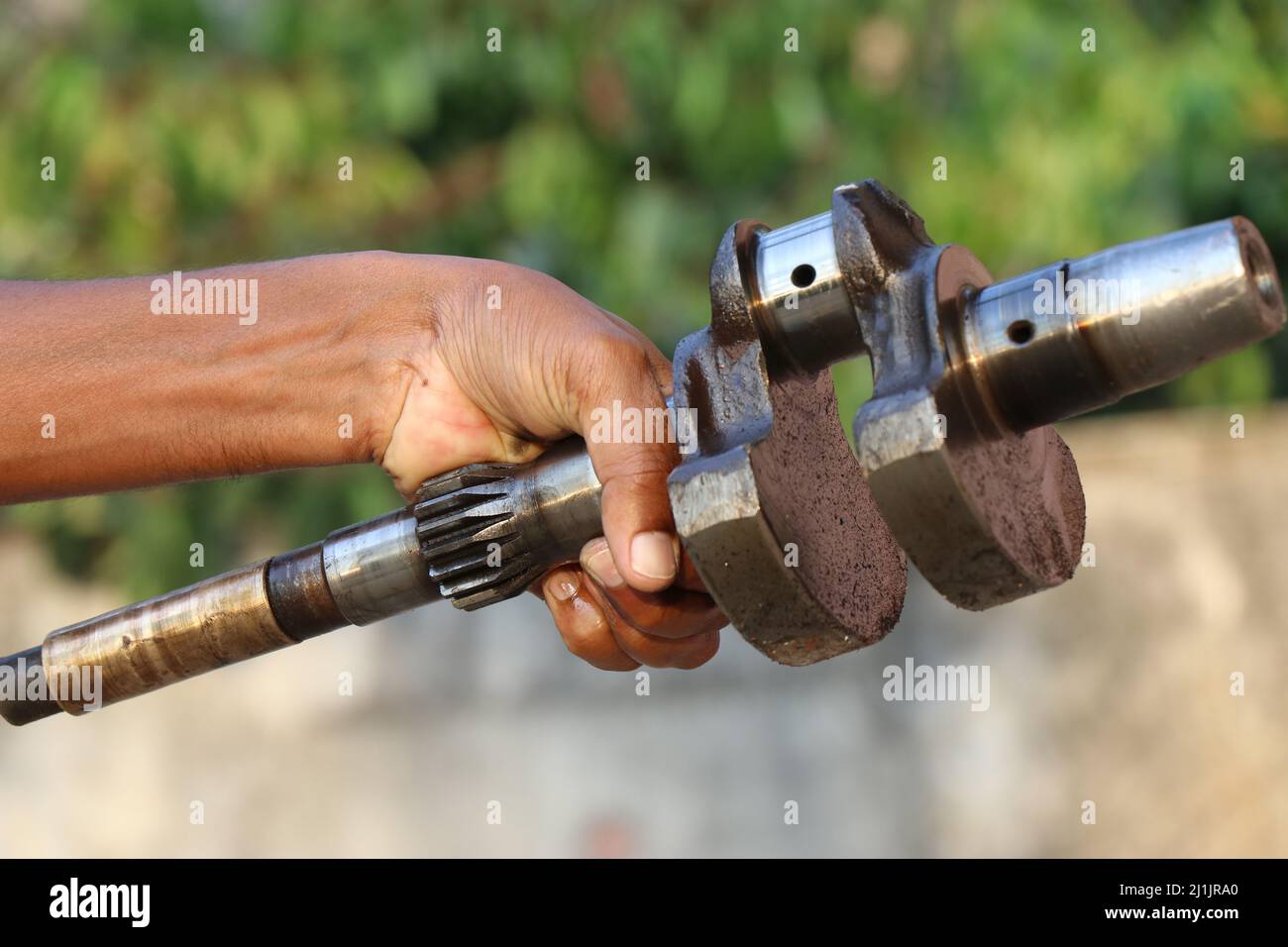 The Crankshaft of a single-cylinder type engine held in hand, The Main part of internal combustion engines Stock Photo