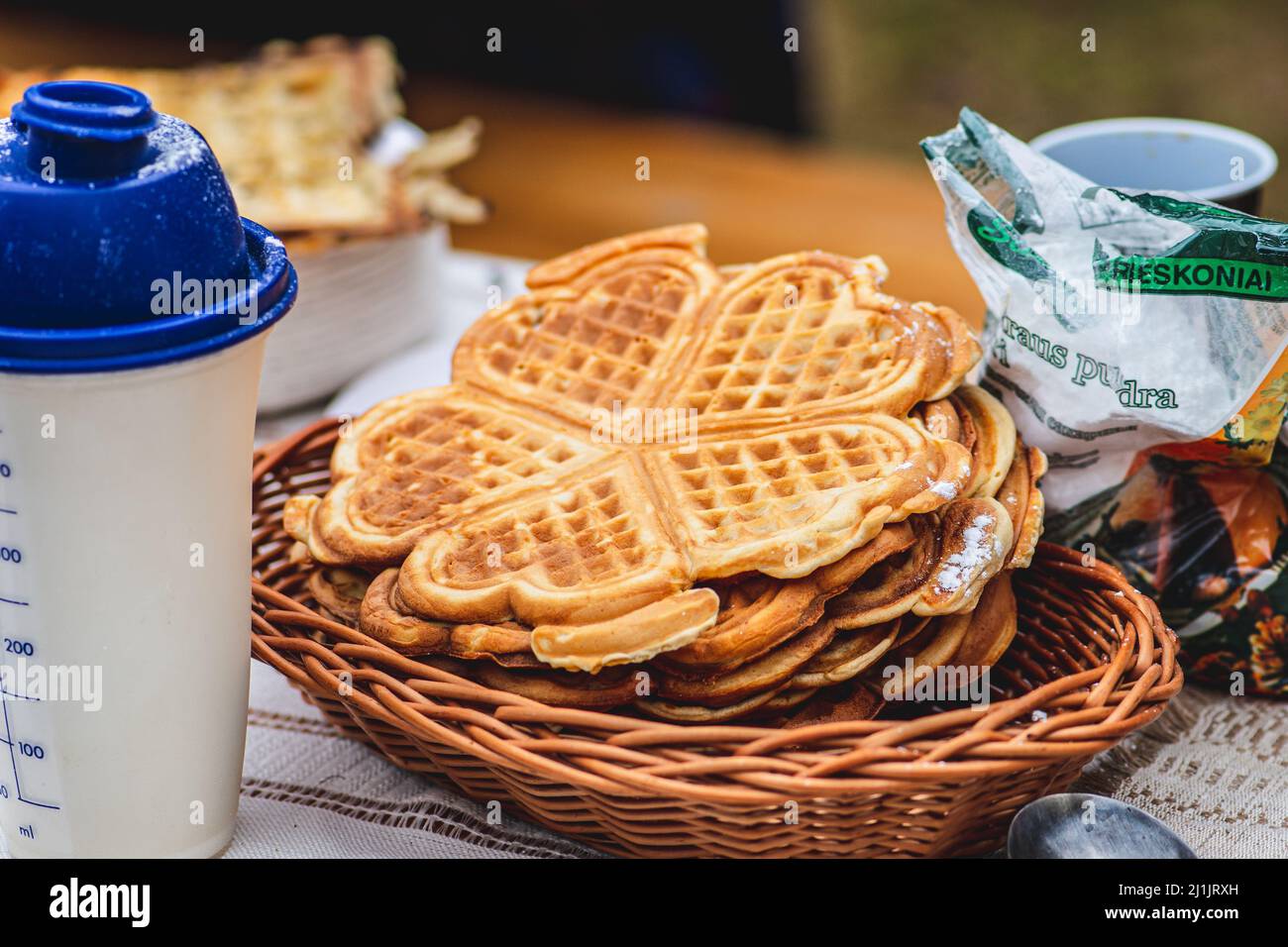 Waffle or waffles in a wicker basket, dish made from leavened batter or dough that is cooked between two plates that are patterned Stock Photo