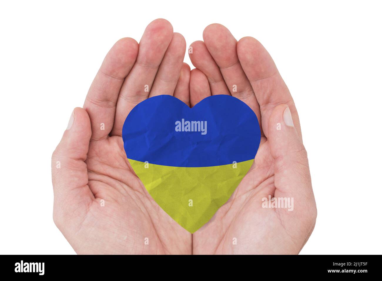 Male hands holding paper heart painted of ukraine flag on white background. Stock Photo