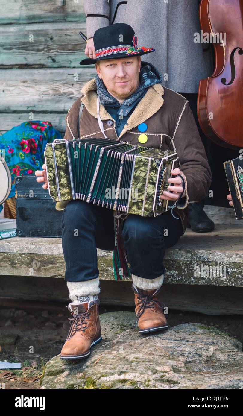 Rumsiskes, Lithuania - February 26 2022: Traditional musicain playing accordion in Rumsiskes, Lithuania during Uzgavenes, a Lithuanian folk festival Stock Photo