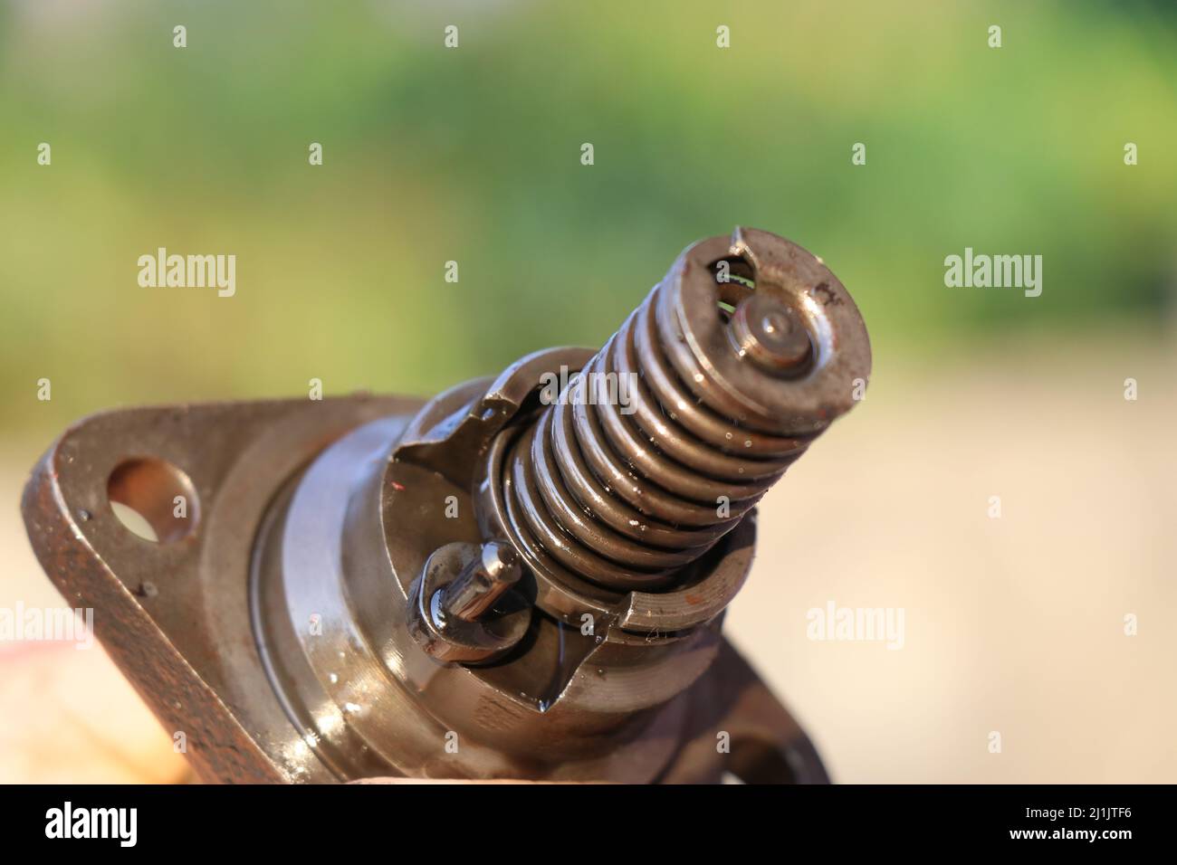 Fuel injector spring part closeup with oil all over the body, Fuel injecting part inside the combustion chamber of IC engine Stock Photo