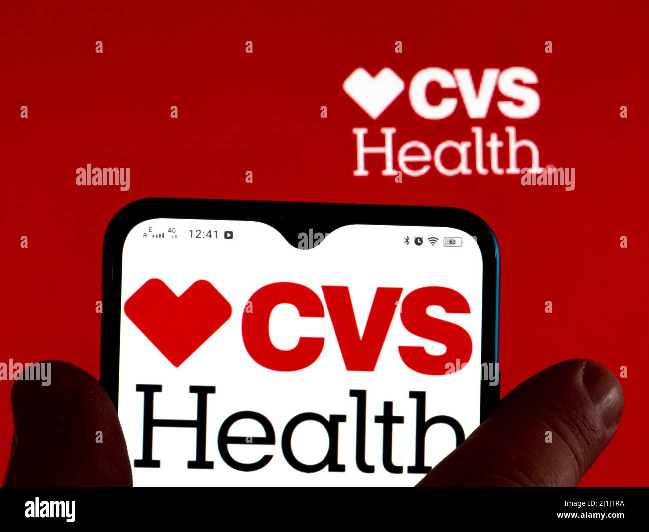 In this photo illustration, the CVS Health logo is displayed on a smartphone screen with a CVS Health Corporation logo in the background Stock Photo