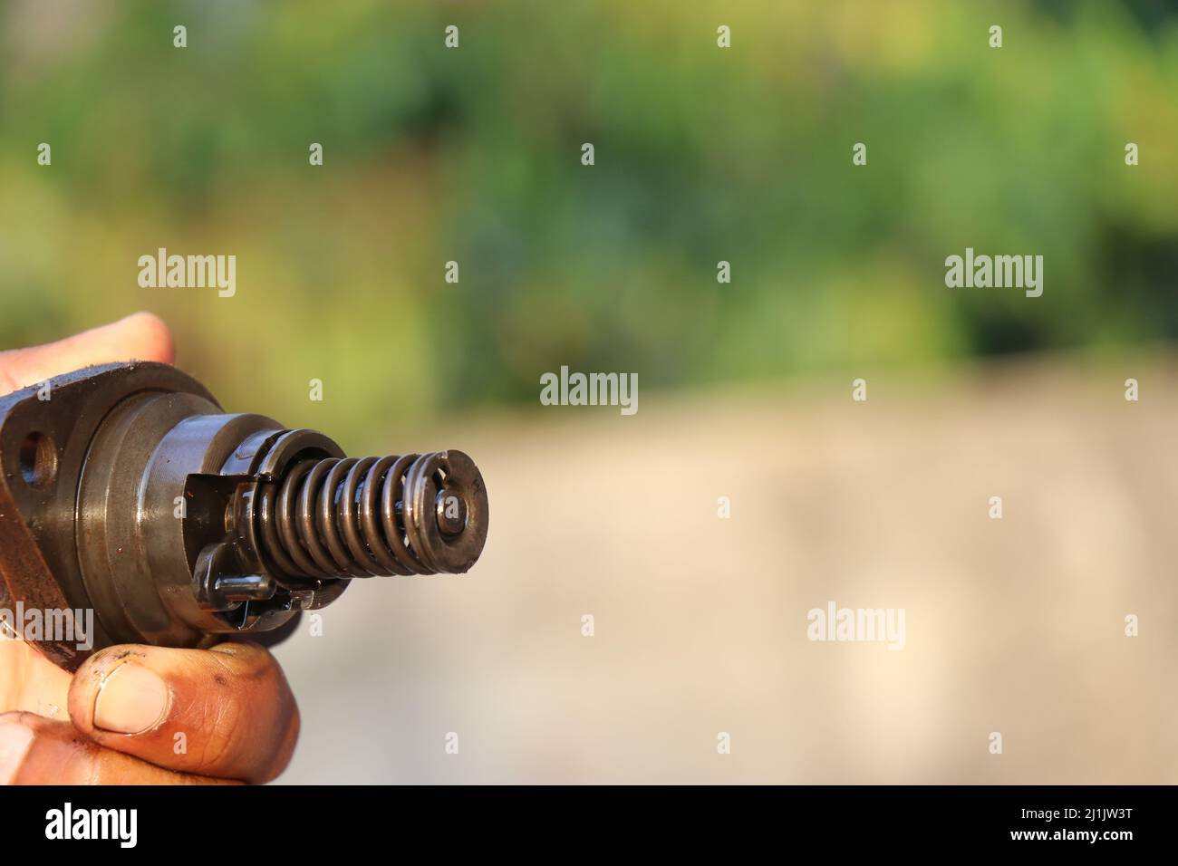 Close view of Spring and other parts of diesel fuel injector held in the hand Stock Photo