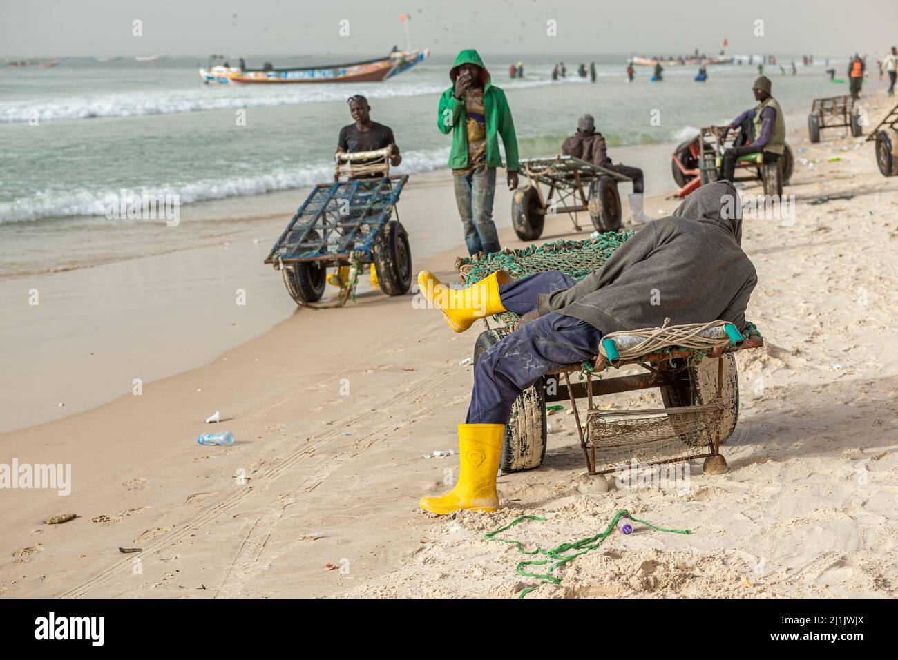 A porter resting on a cart after downloading loads at Nouakchott fish market, Mauritania Stock Photo
