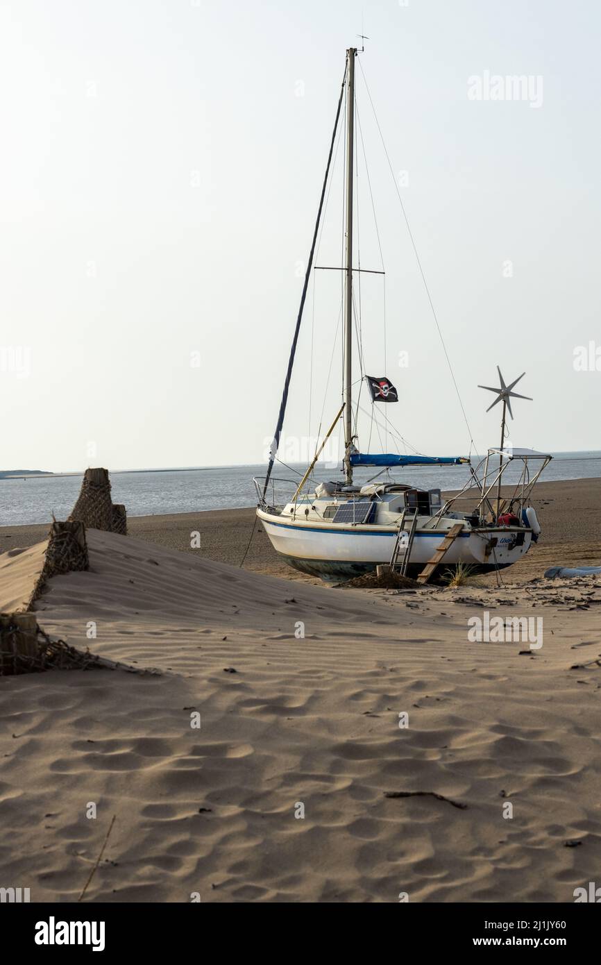 A sailing yacht at high tide on Instow Beach Stock Photo