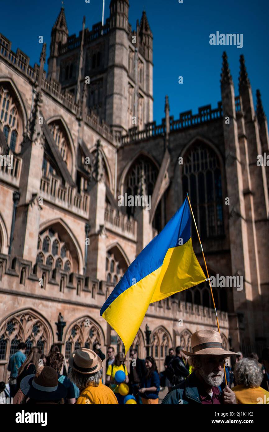 A Ukrainian flag is held outside Bath Abbey in the UK city of Bath ...