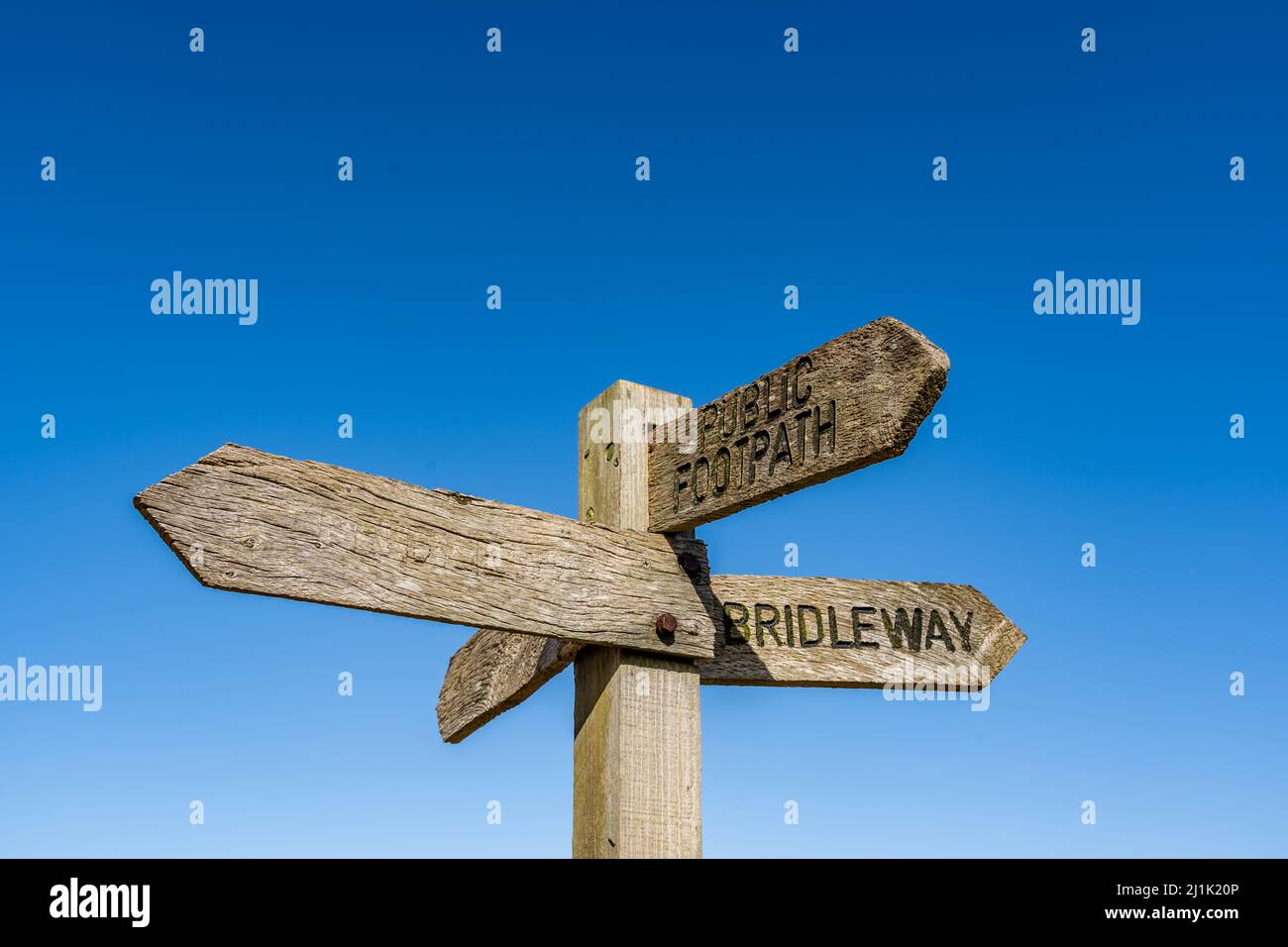 Multidirectional wooden signpost showing public footpaths and bridleways in the rural countryside Stock Photo