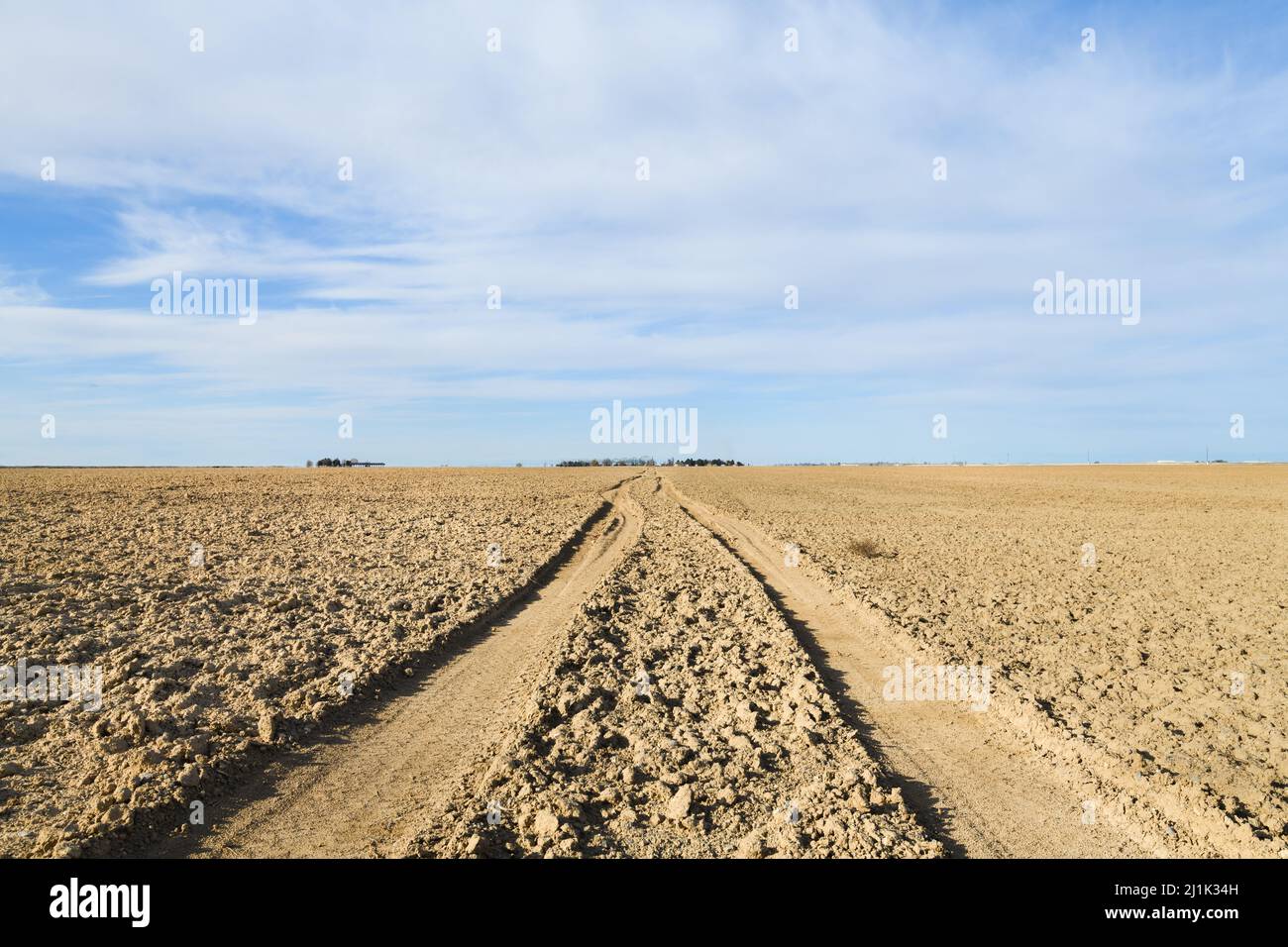Ploughed field with tire tracks leading into the distance of the fertile farmalnd of Eastern Washington State Stock Photo