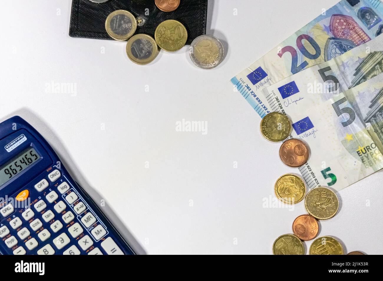 European money with black wallet on white desk as white background with different euro coins and euro bank notes with calculator financial management Stock Photo