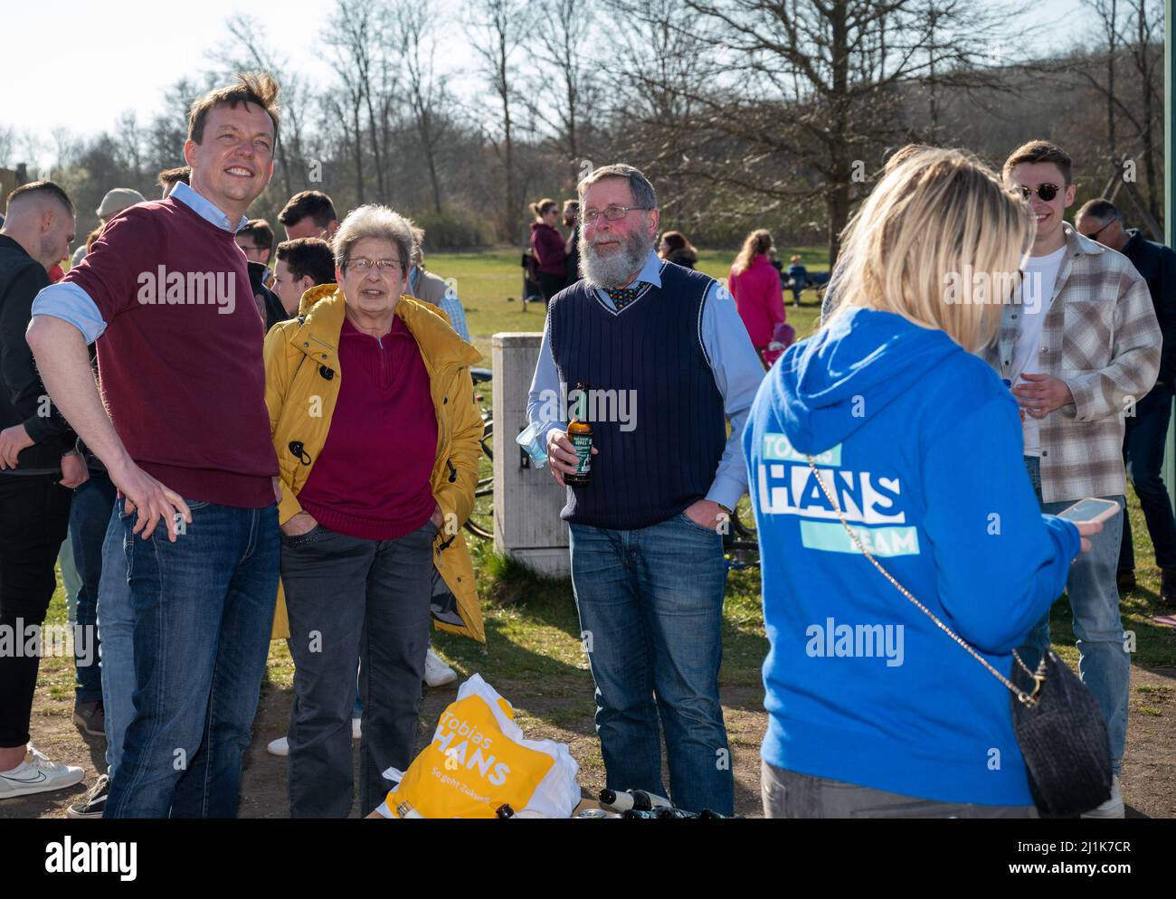 Bosen, Germany. 26th Mar, 2022. Saarland's Minister President Tobias Hans  (l, CDU) talks to passers-by at Bostalsee as part of his election campaign.  A new state parliament will be elected in Saarland