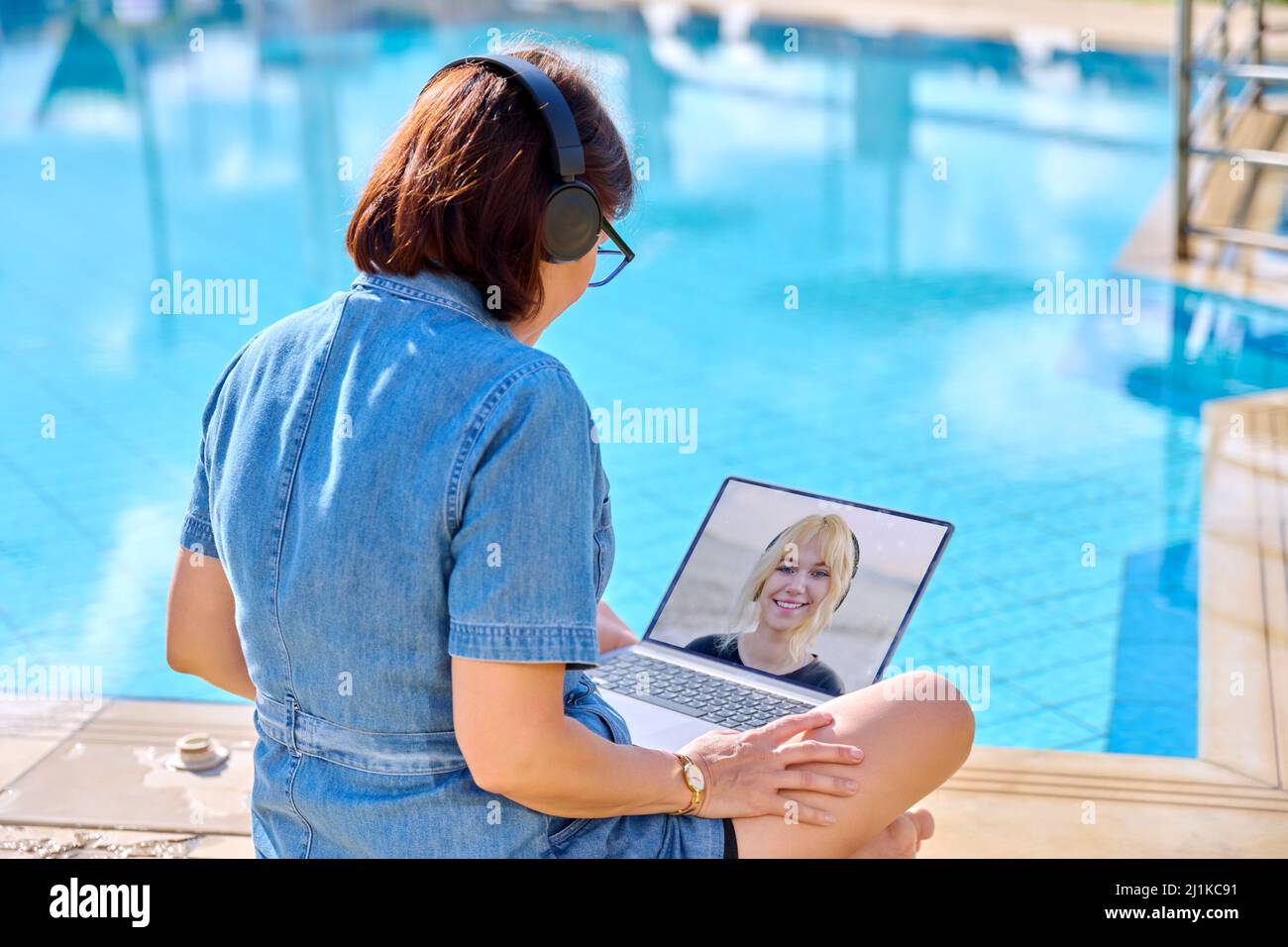 Mother talking to teenage daughter online using video link on laptop. Stock Photo