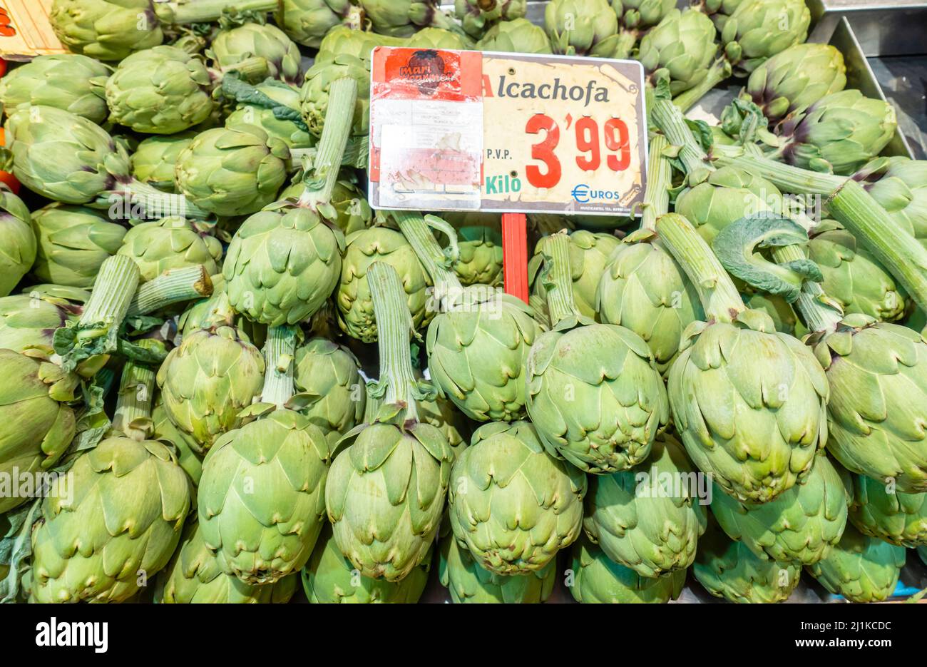 Artichokes alcachofa with a price tag on the shelf in the Mercado de la Paz, Madrid, Spain Stock Photo