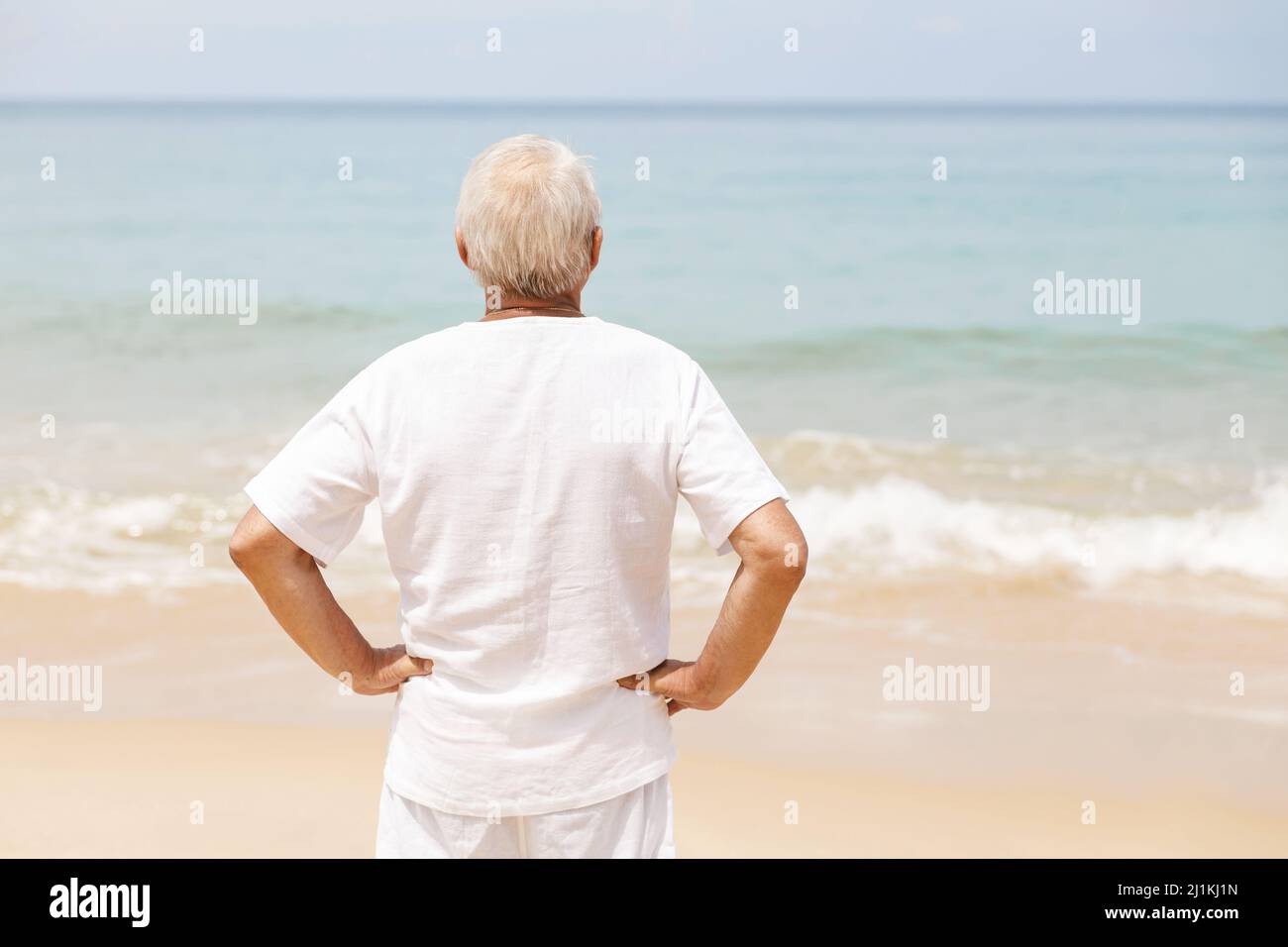 Happy senior man walking on the beach Stock Photo