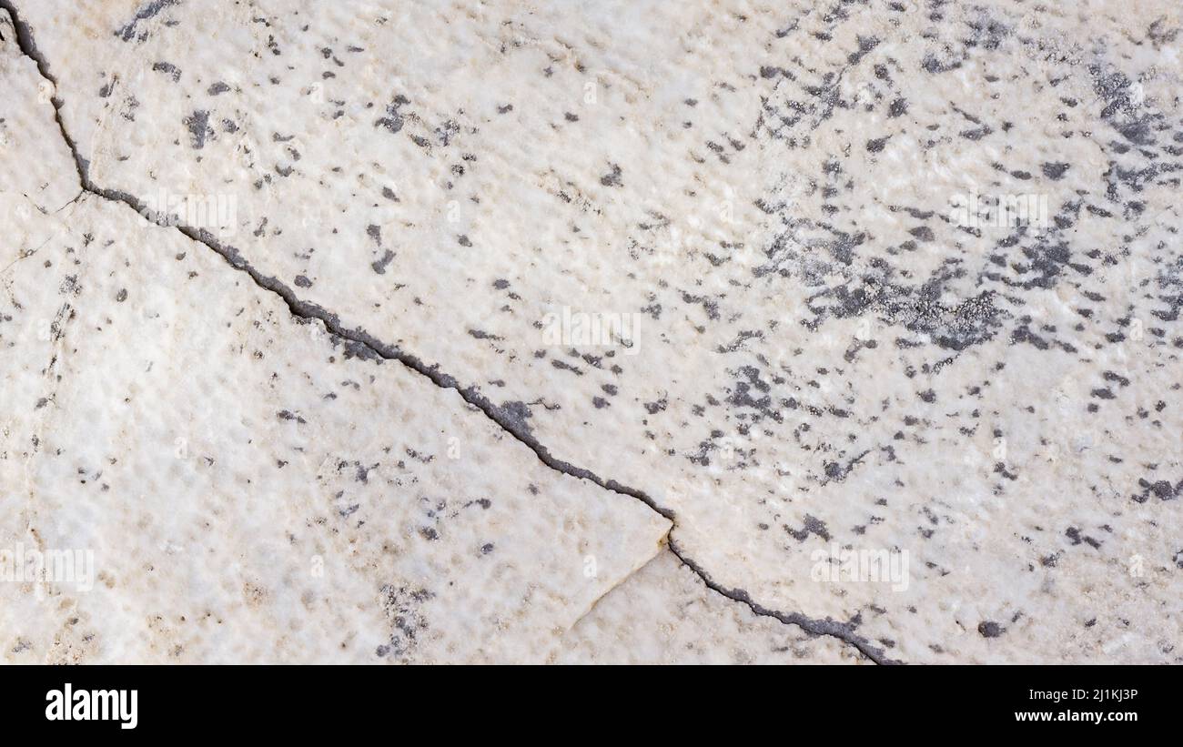 Cracked antique marble texture. Weathercracked stone wall. Marble