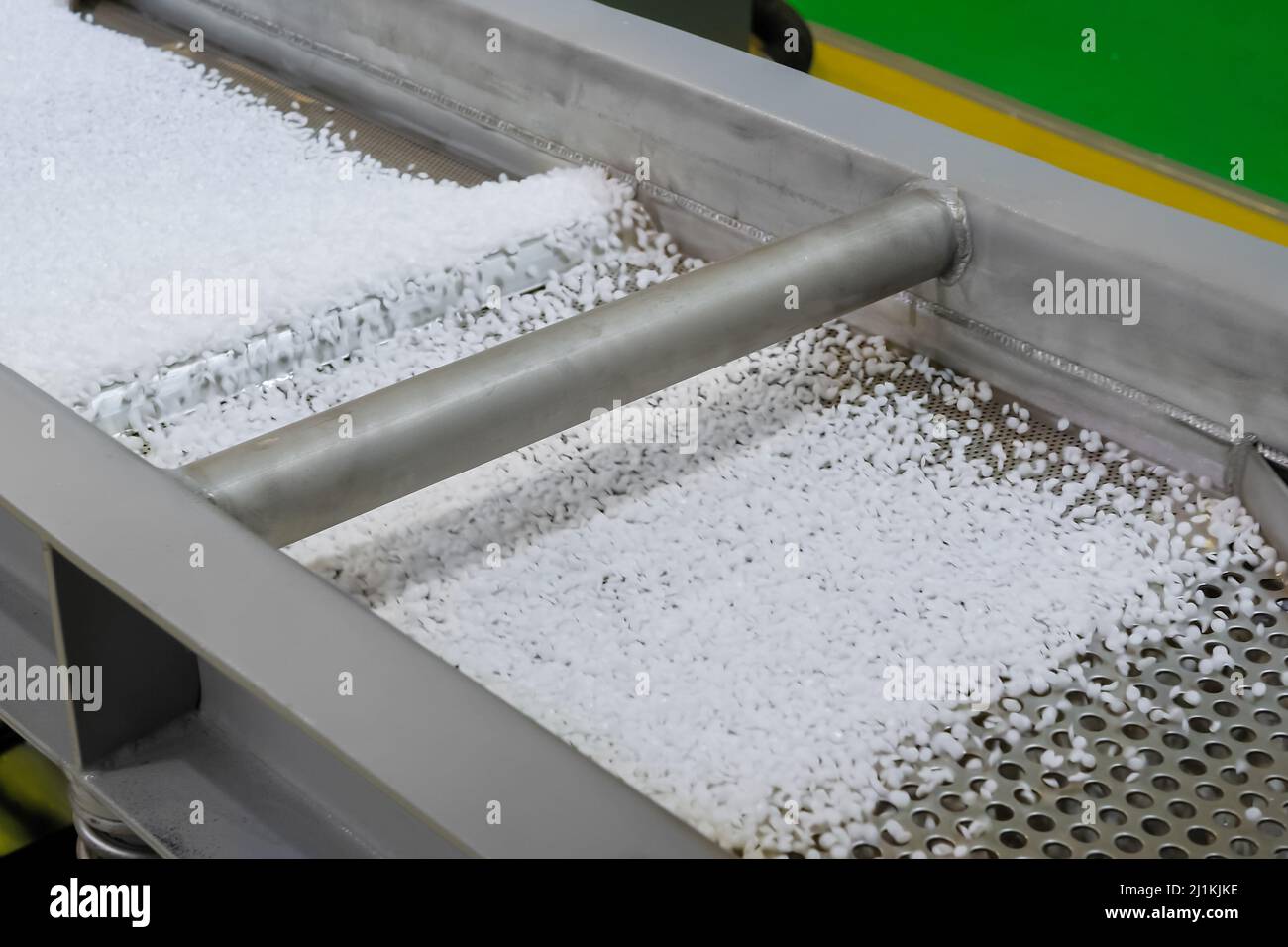 Recycled plastic granules on automatic shale shaker, conveyor belt Stock Photo