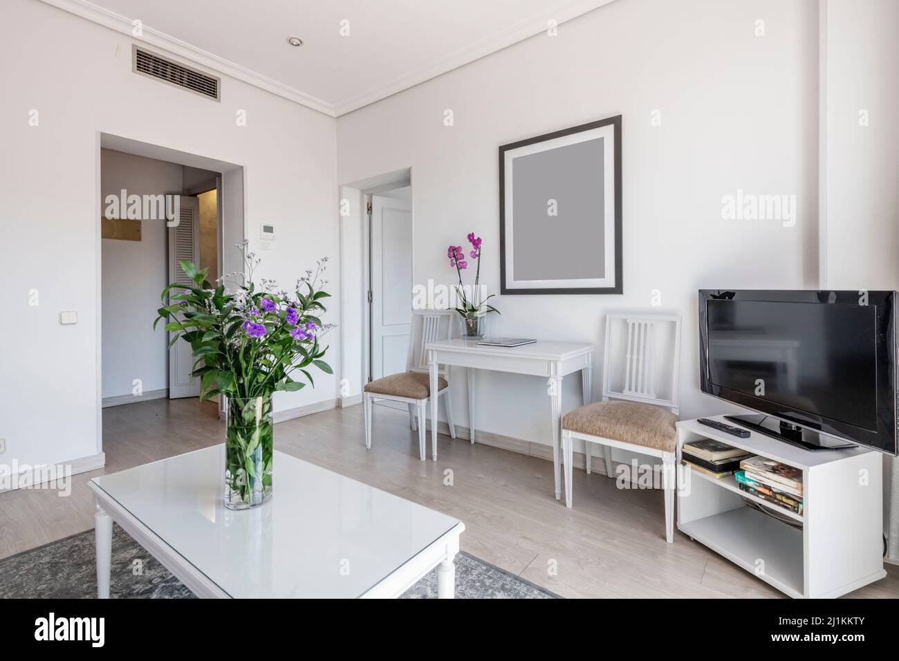 living room with white wooden furniture, table with flat tv and flowers