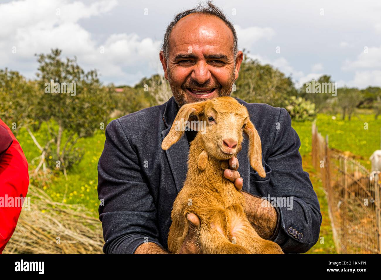 Farmer in North Cyprus with small Aleppo goat. The goat has distinctive long ears. In North Cyprus it is bred for its high milk yield. In the village of Akdeniz, which translated means Mediterranean Sea, you get an impression of typical Cypriot country life. Mayor Tarik shows the goats which are only one day old Stock Photo