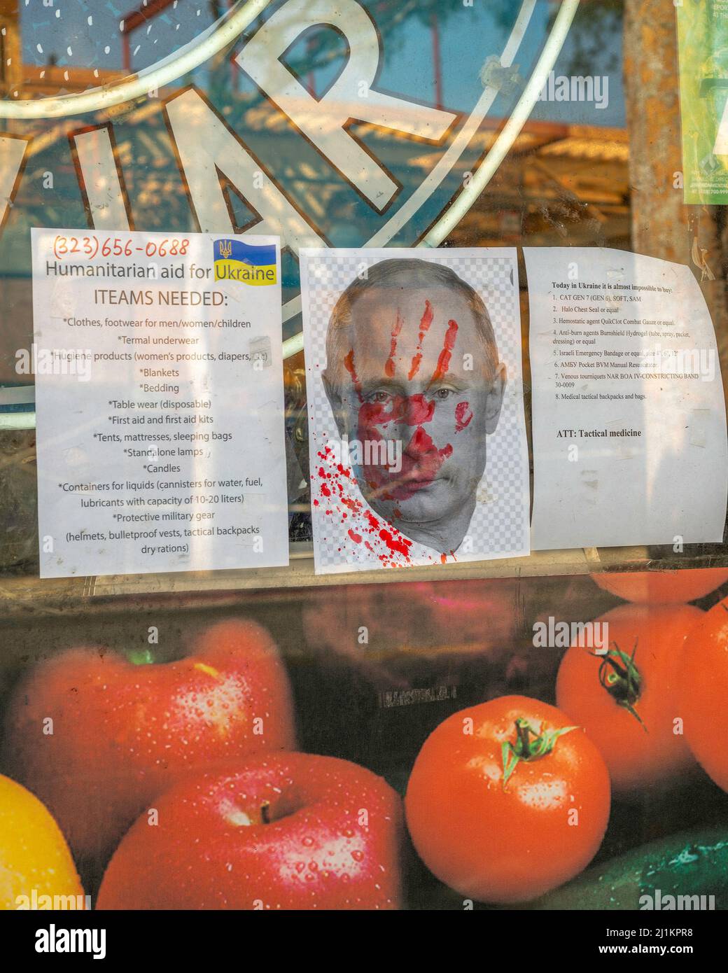 West Hollywood, CA, USA - March 26, 2022: Close up of a Ukrainian store window with flyers promoting aid for Ukraine as well as an image of Putin with Stock Photo