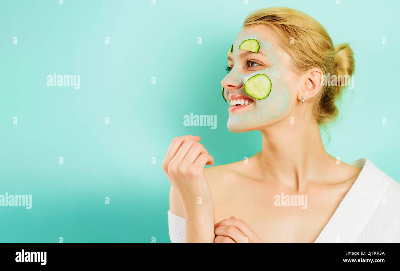Beautiful girl with facial mask and cucumber slices. Woman in beauty salon. Cosmetics procedure. Spa. Stock Photo
