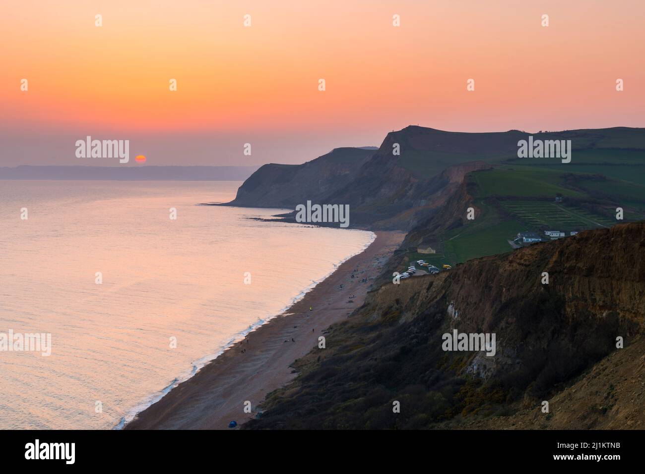 Eype, Dorset, UK. 26th March 2022. UK Weather. The sky glows orange at ...