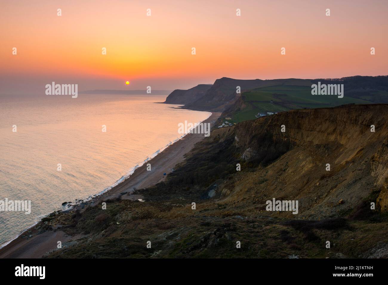 Eype, Dorset, UK. 26th March 2022. UK Weather. The sky glows orange at ...