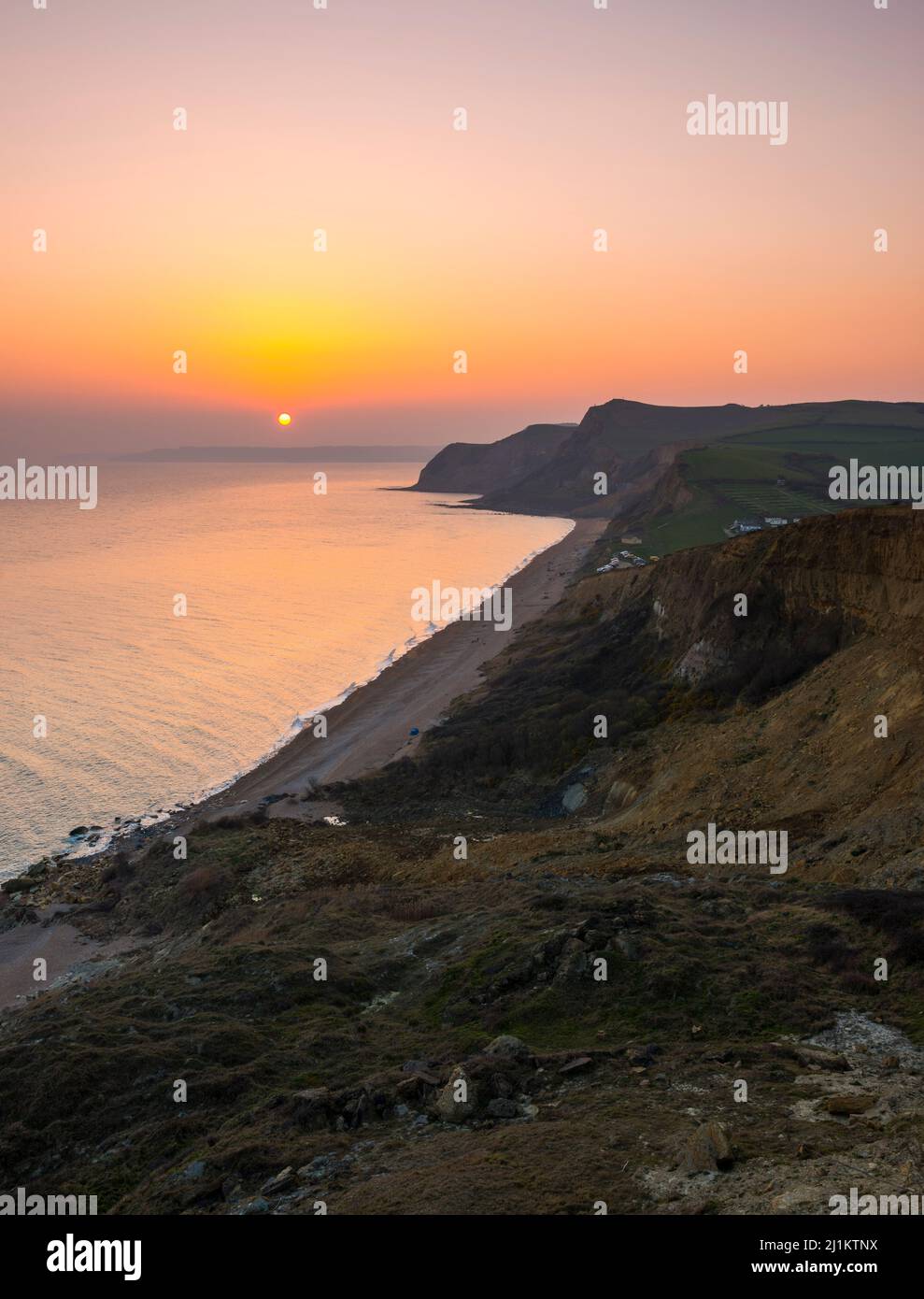 Eype, Dorset, UK. 26th March 2022. UK Weather. The sky glows orange at ...