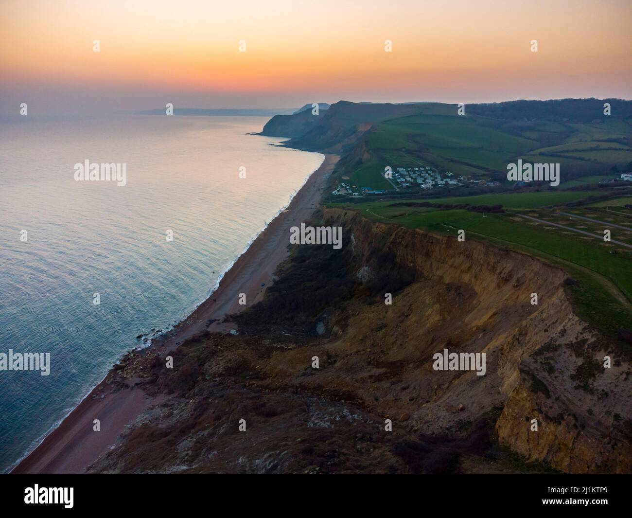 Eype, Dorset, UK. 26th March 2022. UK Weather. The sky glows orange at ...