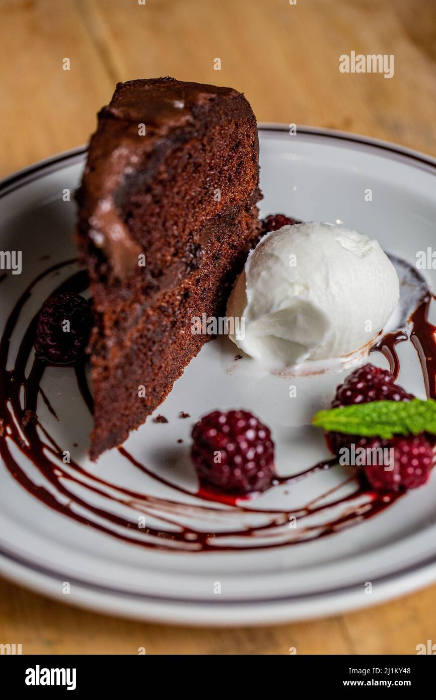 A closeup of a piece of chocolate cake with vanilla ice cream and ...