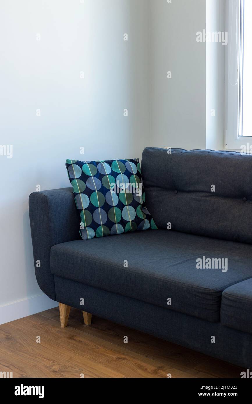 Dark blue sofa with blue and turquoise cushion in a white room Stock Photo