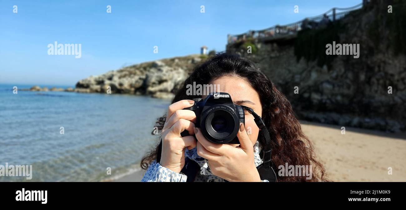 Istanbul,Turkey- February 12 2022: A beach in Sile, sunny day trip on the seaside, traveler’s aspect. Young woman photographer with Canon EOS 550d. Stock Photo