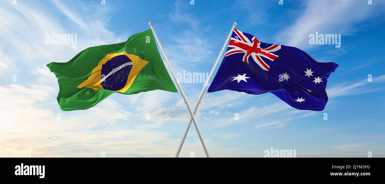 two crossed flags Brazil and Australia waving in wind at cloudy sky ...