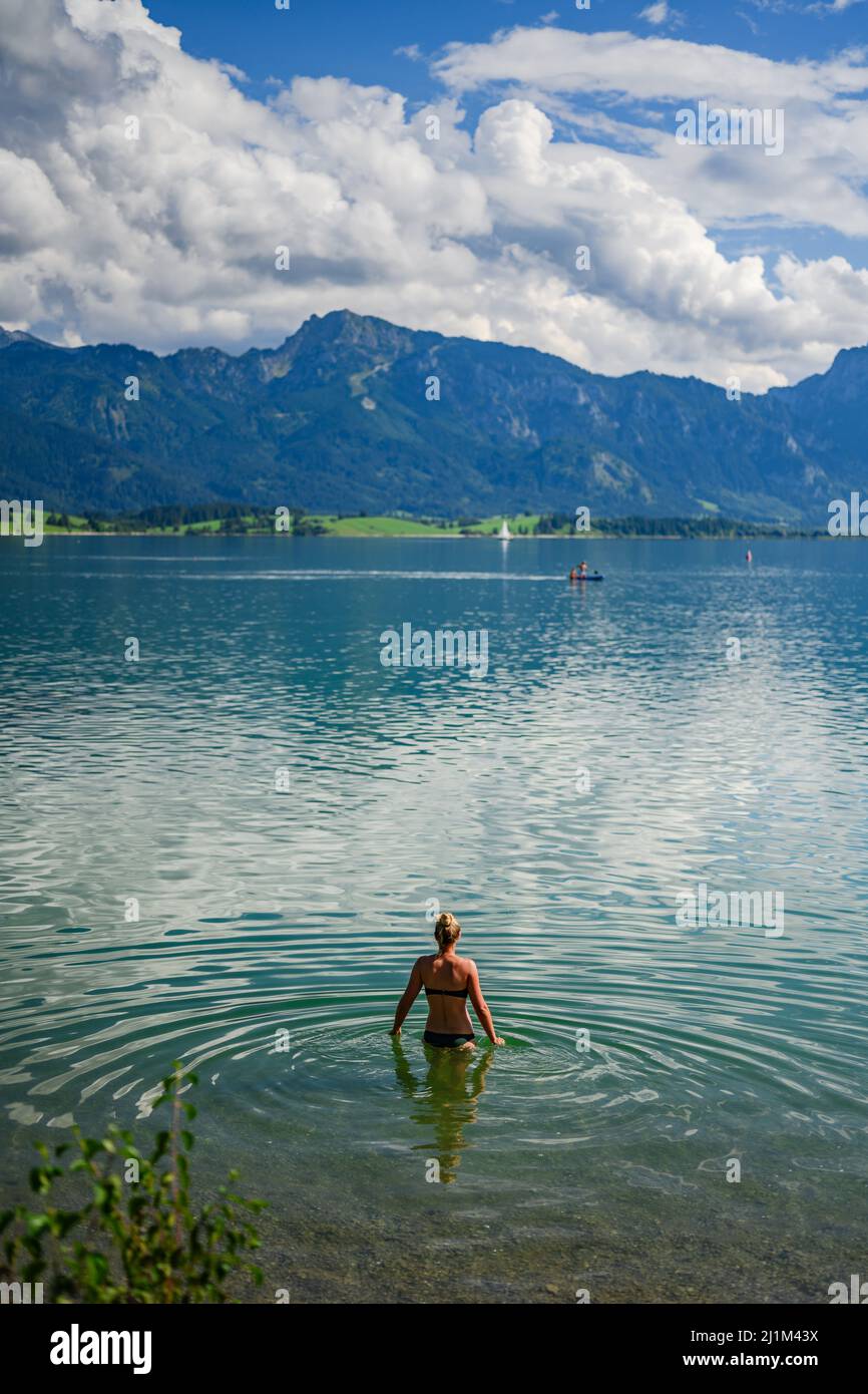 Woman taking bath at Forggensee in bavaria Stock Photo