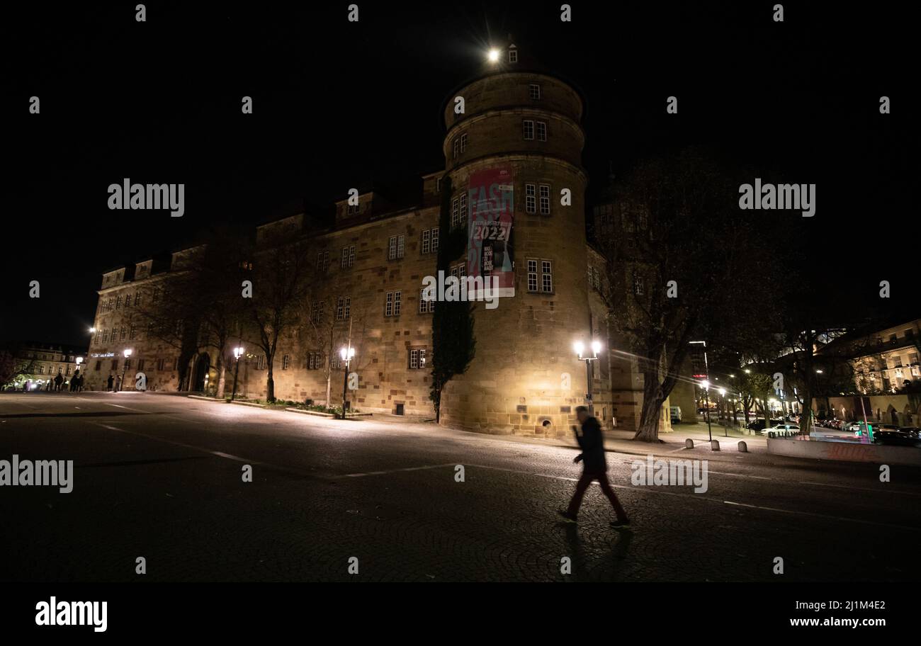 Stuttgart, Germany. 26th Mar, 2022. A man walks past the dark Old Castle during Earth Hour. Cities around the world are taking part in the climate protection campaign, in which the lights are switched off at landmarks, landmark buildings and other public facilities. Credit: Christoph Schmidt/dpa/Alamy Live News Stock Photo
