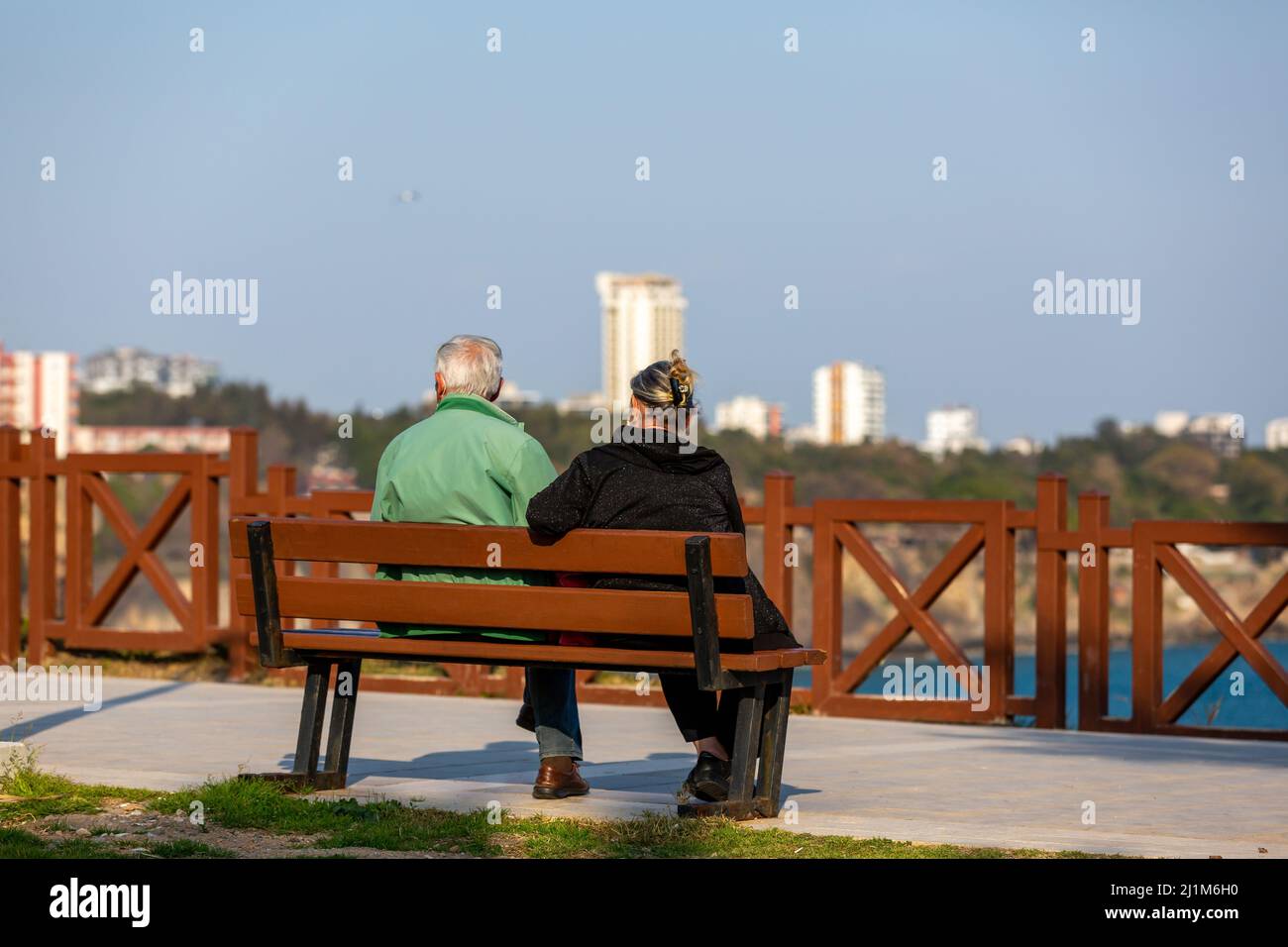 Turkey - Antalya Elderly couple sitting on a bench by the sea.People watching the scenery by the sea. Stock Photo