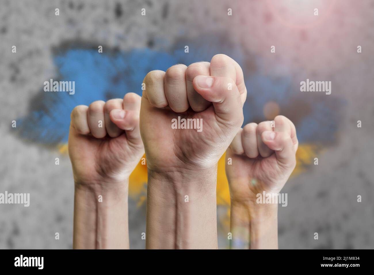 Support for Ukraine and solidarity. Help to the Ukrainian people in wartime. Fists as a symbol of support against the background of the Ukrainian flag Stock Photo