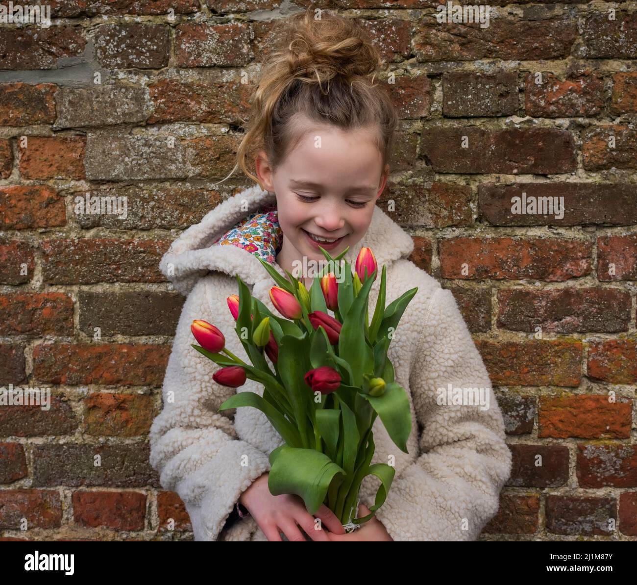 portrait of young girl holding flowers smiling Stock Photo - Alamy