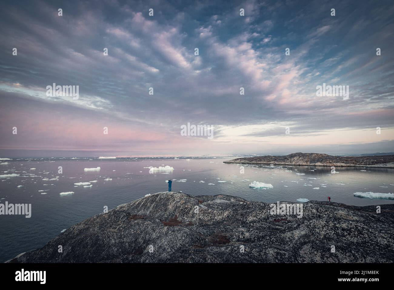 Big icebergs floating over sea and photographer over mountain Stock Photo