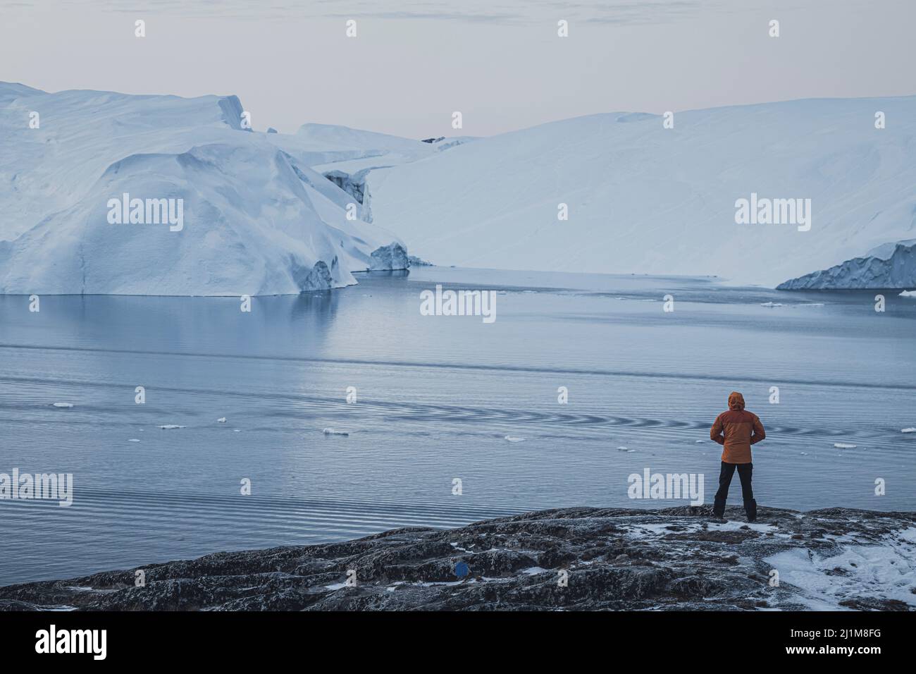 man observe the extreme icebergs in north pole Stock Photo