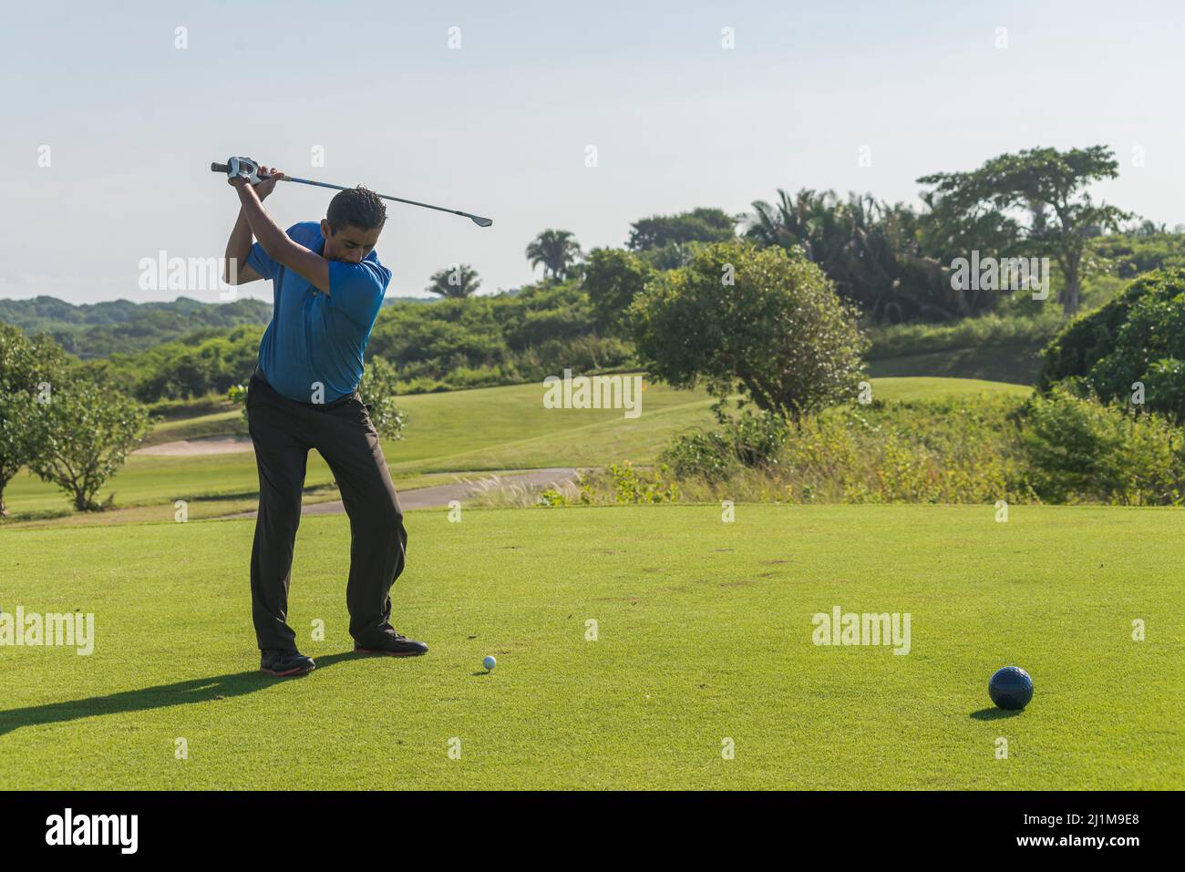 Latin golfer playing early in the morning Stock Photo